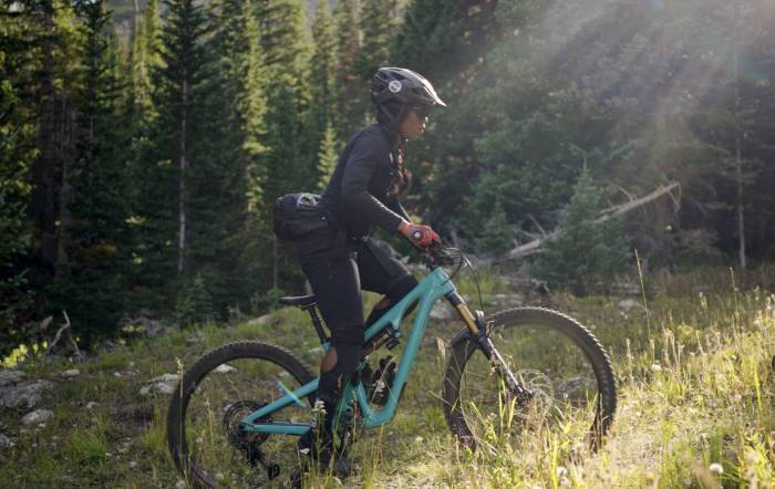 brooke goudy biking on a teal YETI mountain bike on a green trail in Boulder, Colorado