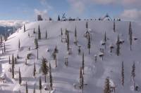 a steep snowy mountainside scattered with terrain features at the natural selection tour course in british columbia