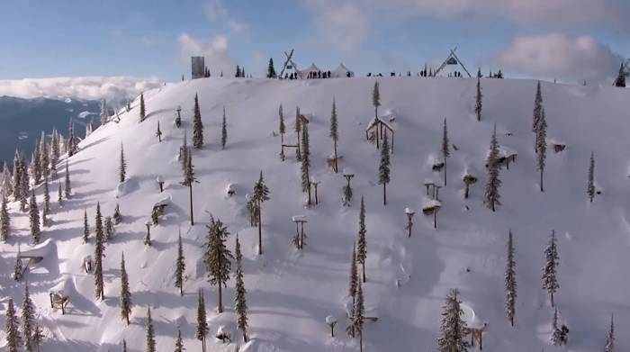 a steep snowy mountainside scattered with terrain features at the natural selection tour course in british columbia