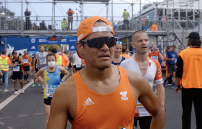 zwift academy runner in orange jersey tank in Berlin Marathon