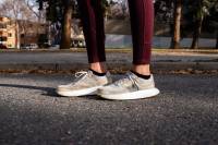 Salomon Index.01 Review: 100 Days in Recyclable Running Shoes Editor Mary Murphy wearing the recyclable Salomon Index.01 white running shoes pauses on pavement mid-run