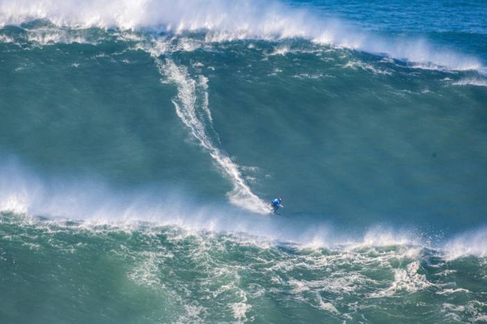 Michelle des Bouillons (BRA) races a Nazare bomb; (still/Laurent Masurel for the World Surf League)