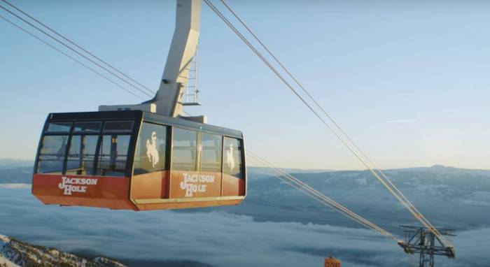 an aerial tram car in the early morning behind a blue sky at jackson hole mountain resort