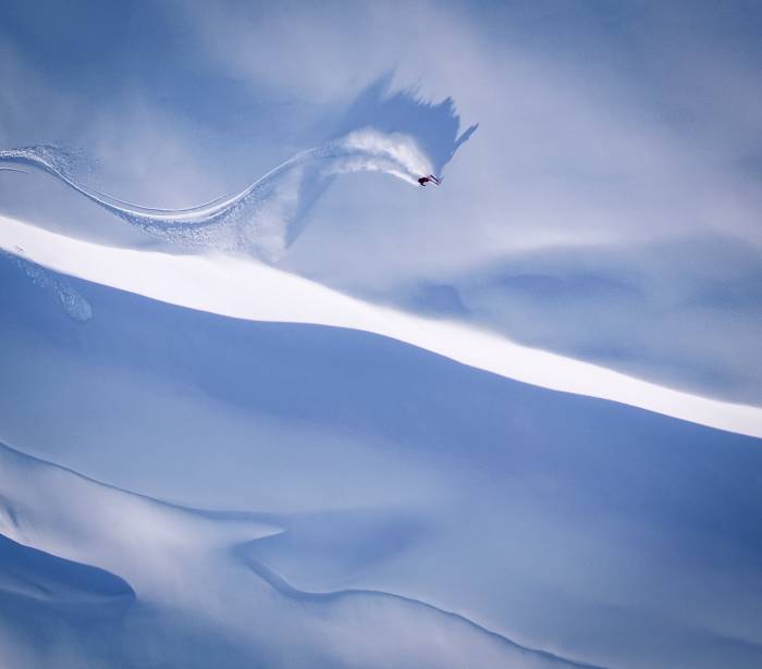 skier descending steep and crisp powdery slope