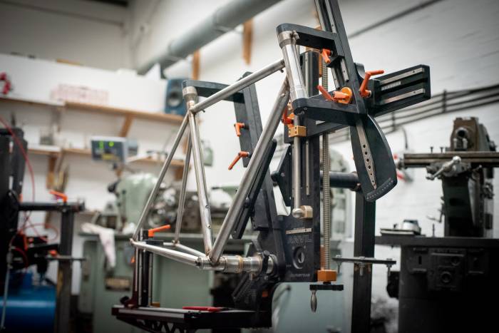 a custom steel bike on a bike stand in a workshop
