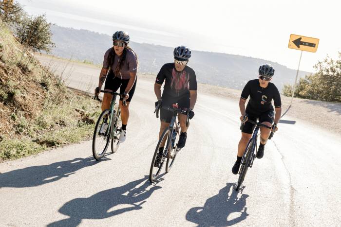 3 Liv cyclists riding together around a curve in a road