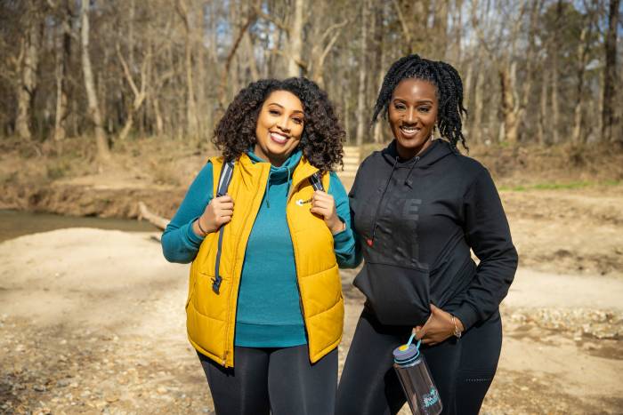 Outdoor Journal Tour founders Michelle (left in a yellow puffy vest) and Kenya Jackson-Saulters (right, in a black hoodie holding a water bottle)