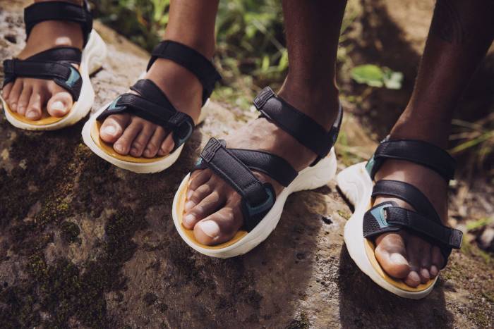 two people with two different skin tones standing on a log wearing the double strap Teva Zymic sandals