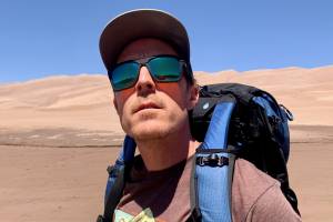 Man wearing sunglasses at sand dunes