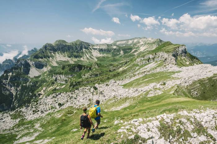 Two hikers wearing the AKU Trekker Pro over some grassy mountains.