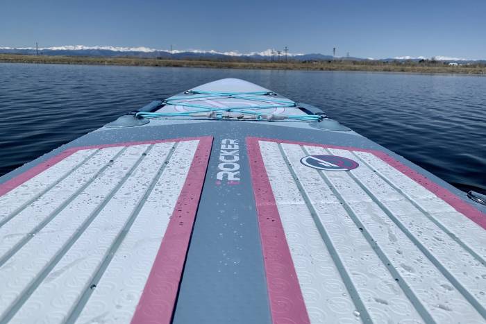 the nose of the irocker ultra series all around SUP in a lake pointed towards some mountains