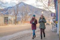 Two women walking down street in a mountain town