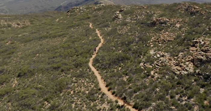 Lucy Bartholomew running along a singletrack trail through Australia