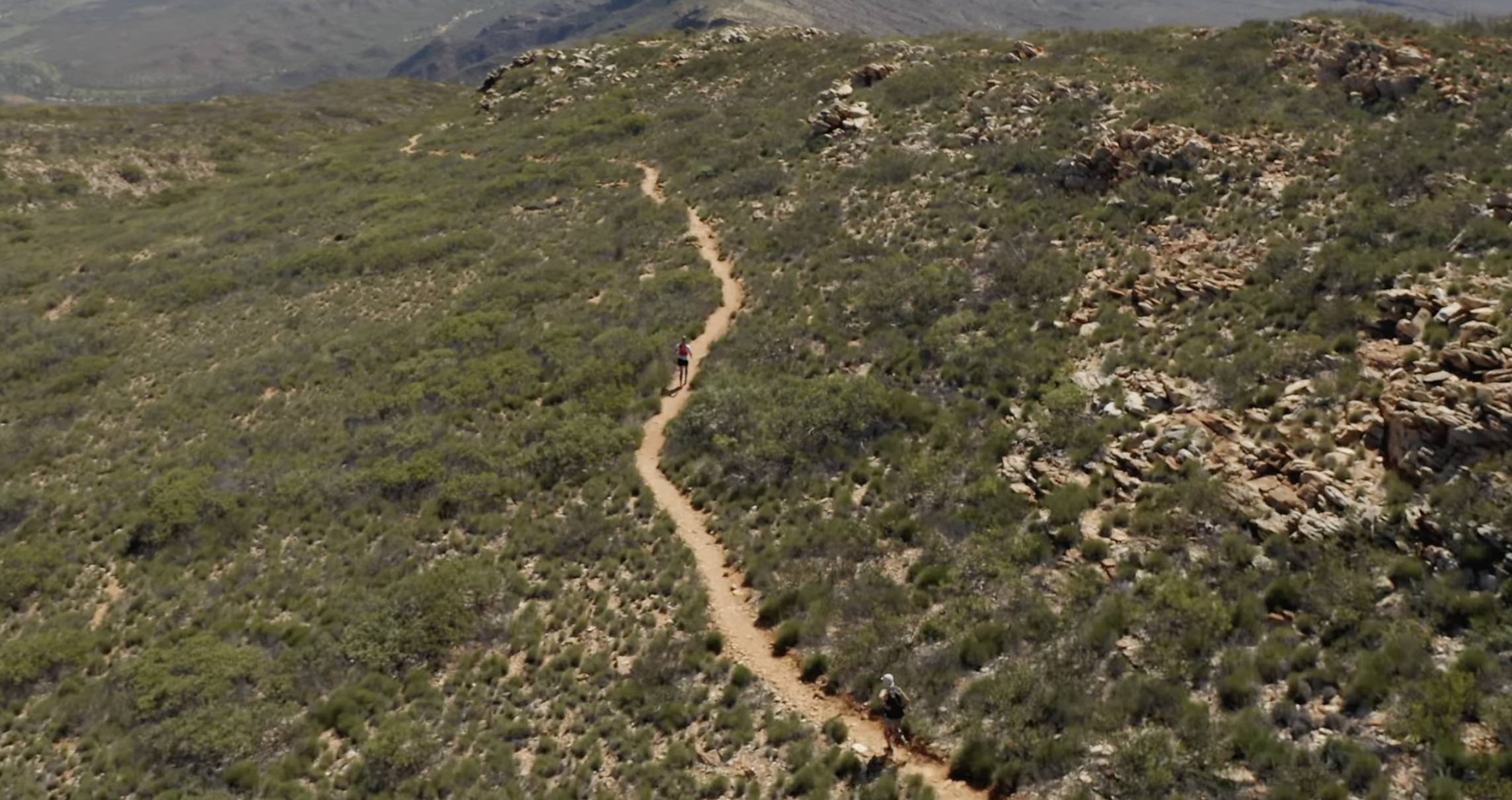 Lucy Bartholomew running along a singletrack trail through Australia