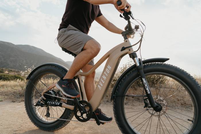 person riding an Aventure e-bike from Aventon with a hill in the background.