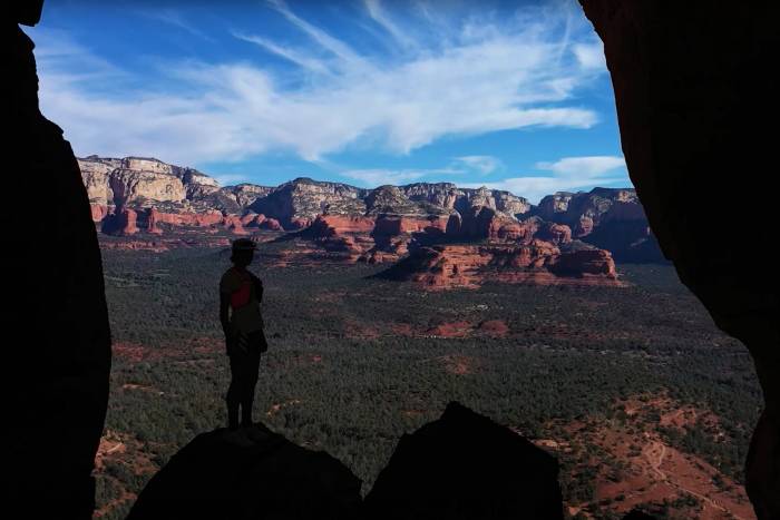 Abby Hall stands on a rock and looks out over a canyon