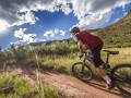 Mountain Bikers Benefit From National Forest Trail Improvement Grants a man in a red jersey rides a mountain bike on a trail in colorado