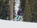 Mary Murphy skiing in the black crows ferus jacket against a backdrop of trees