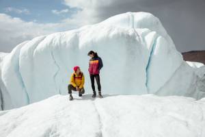 two people standing on a frozen mountain wearing Cotopaxi Fuego Hoodies
