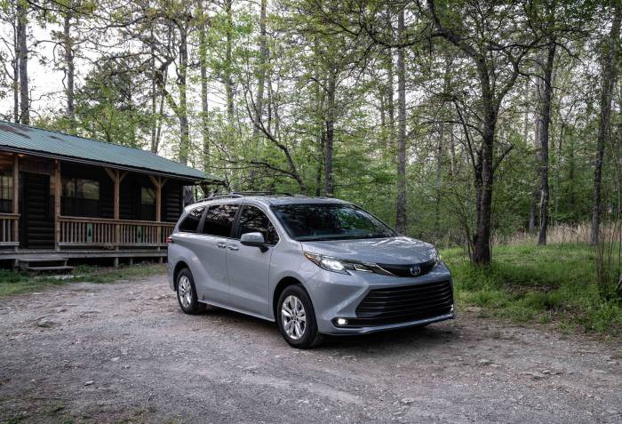 2022 Toyota Sienna Woodland Edition parked in front of a cabin in the woods