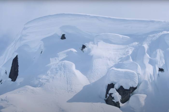a wide view of Parker White navigating large jumps on a snow covered mountain