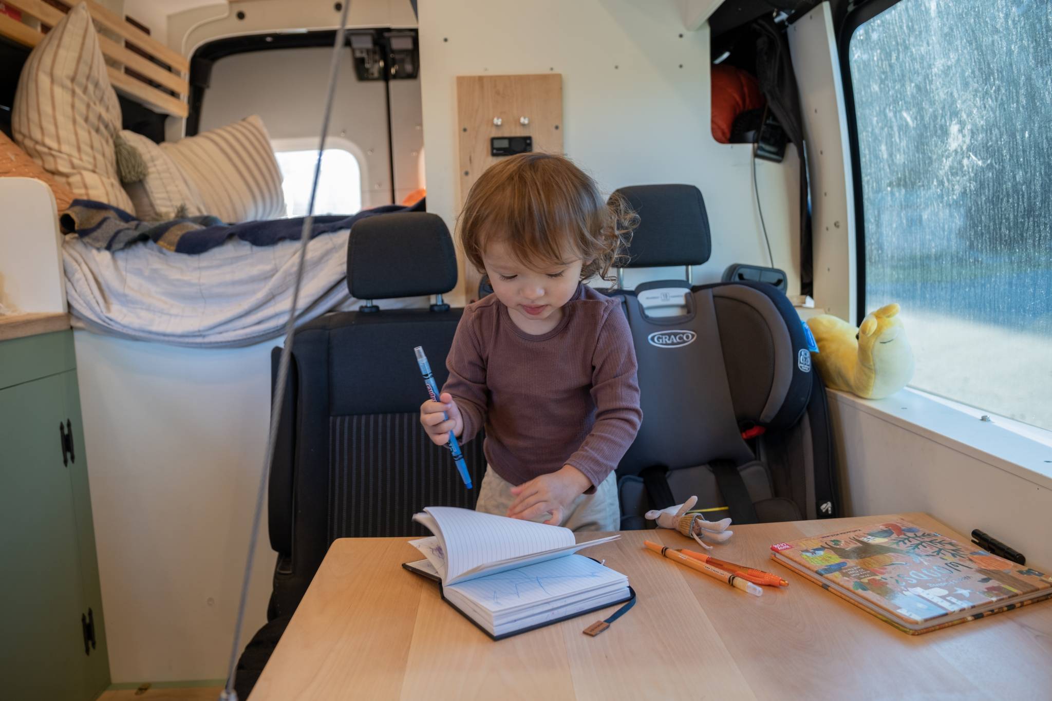 Kid coloring in a converted campervan