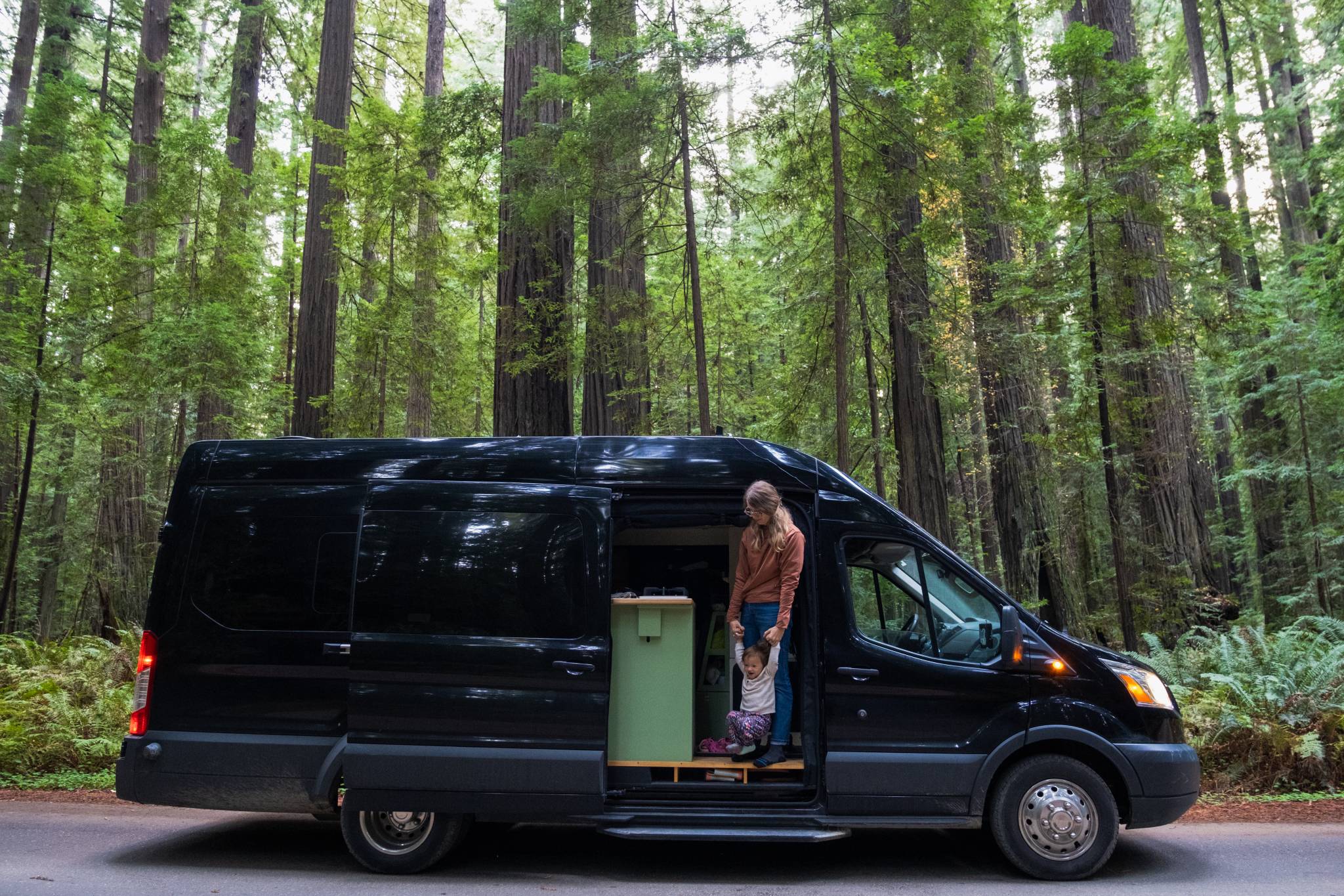 Mother and Child in a Campervan on the Road in a Redwood Forest in California Vanlife