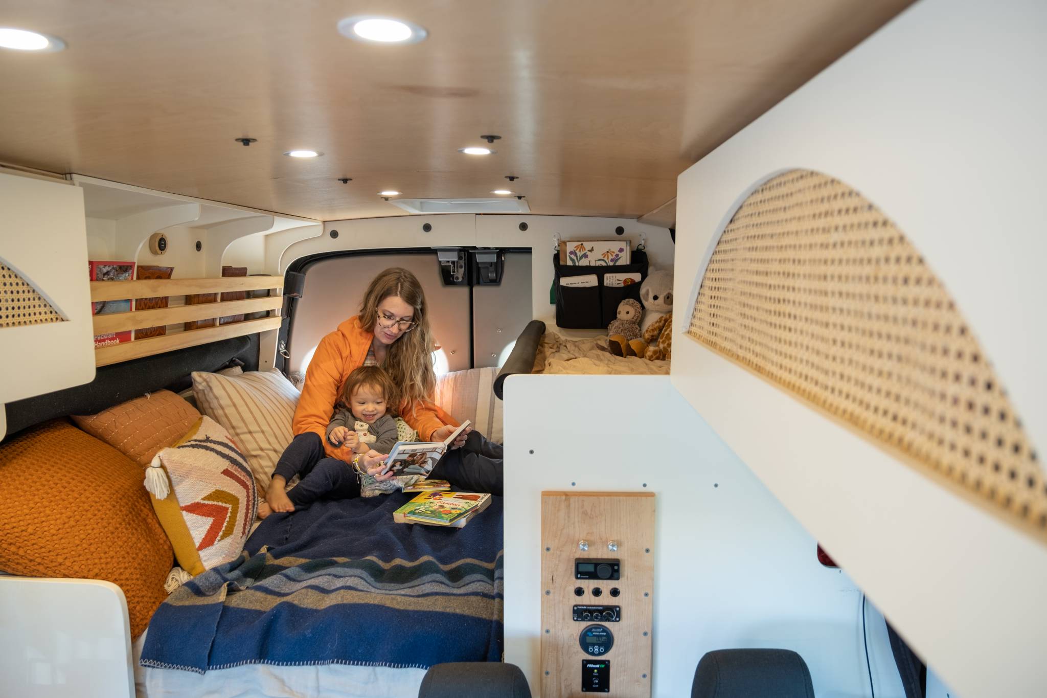 Mother and Daughter Reading in Bed in a Converted Campervan Vanlife With A Kid