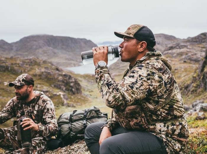 person drinking out of the YETI Yonder bottle during a hunt