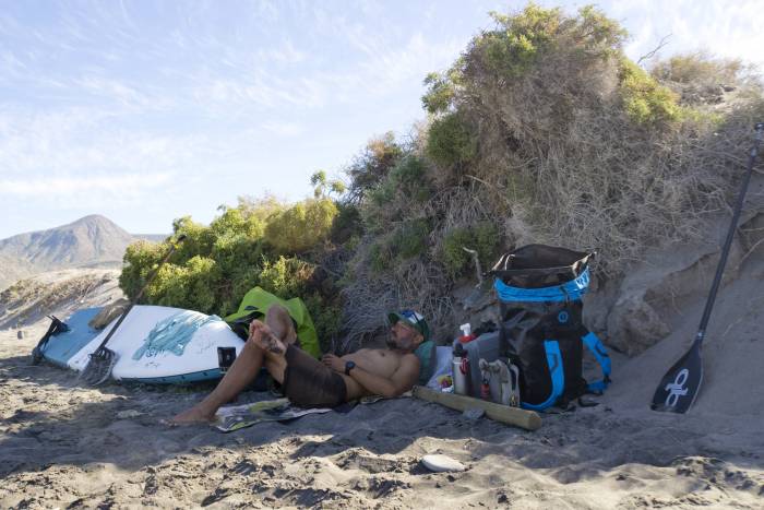 Mustang Survival Highwater 60L Waterproof Gear Hauler man on beach with gear