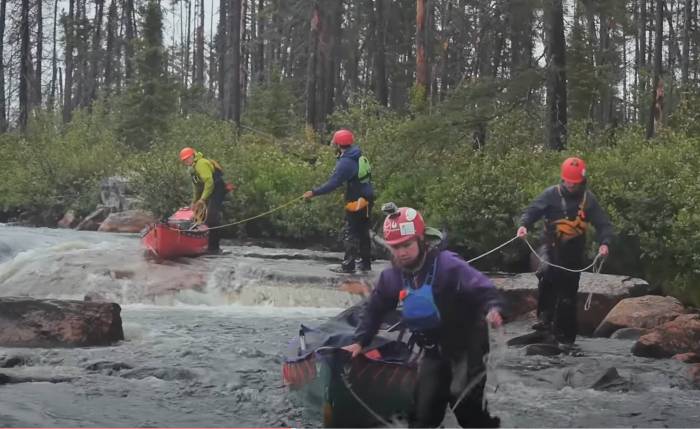 Backcountry canoers enter the water of Quebec’s Tichégami River