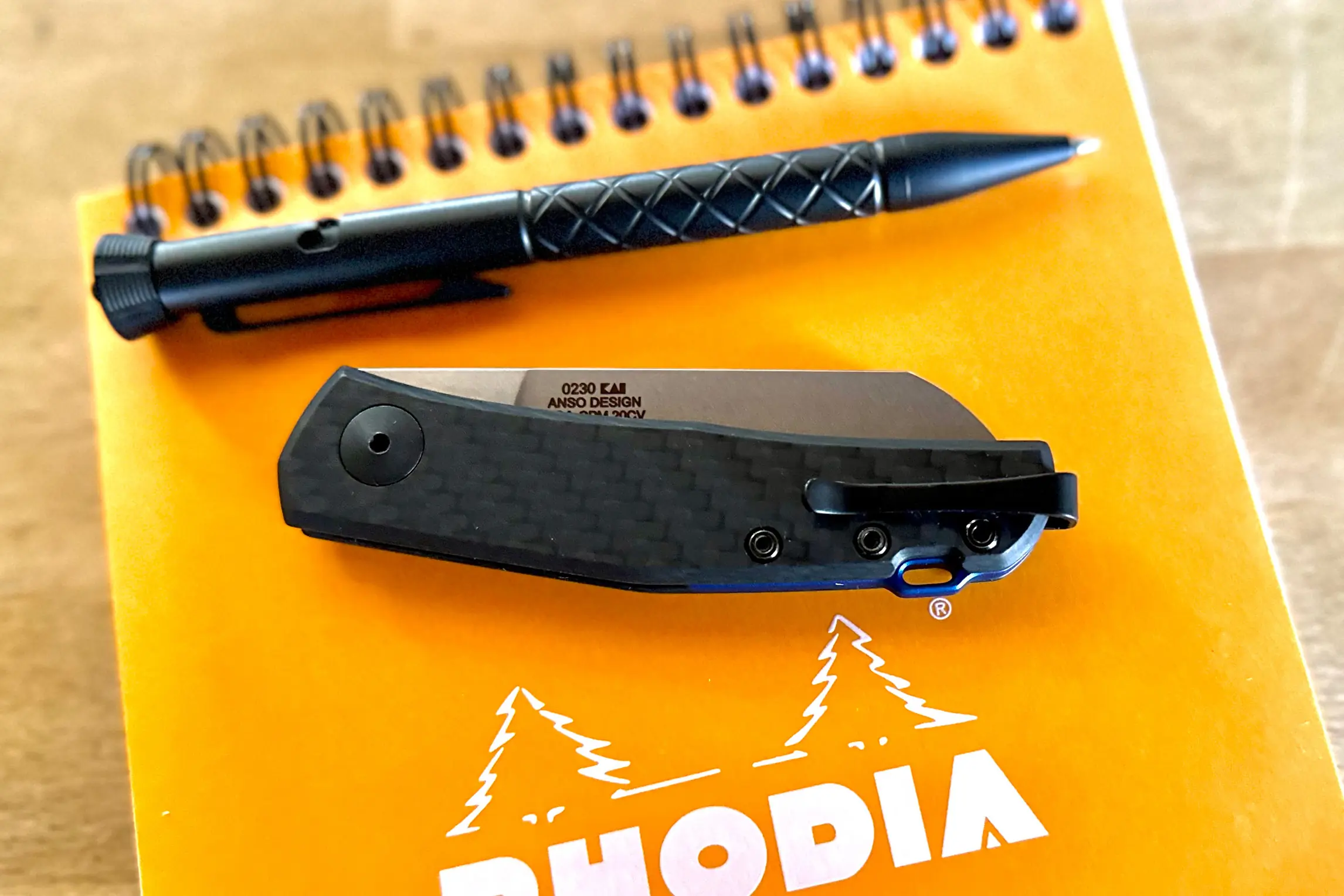 zero tolerance 0230 folding knife closed next to pen and pad of paper.