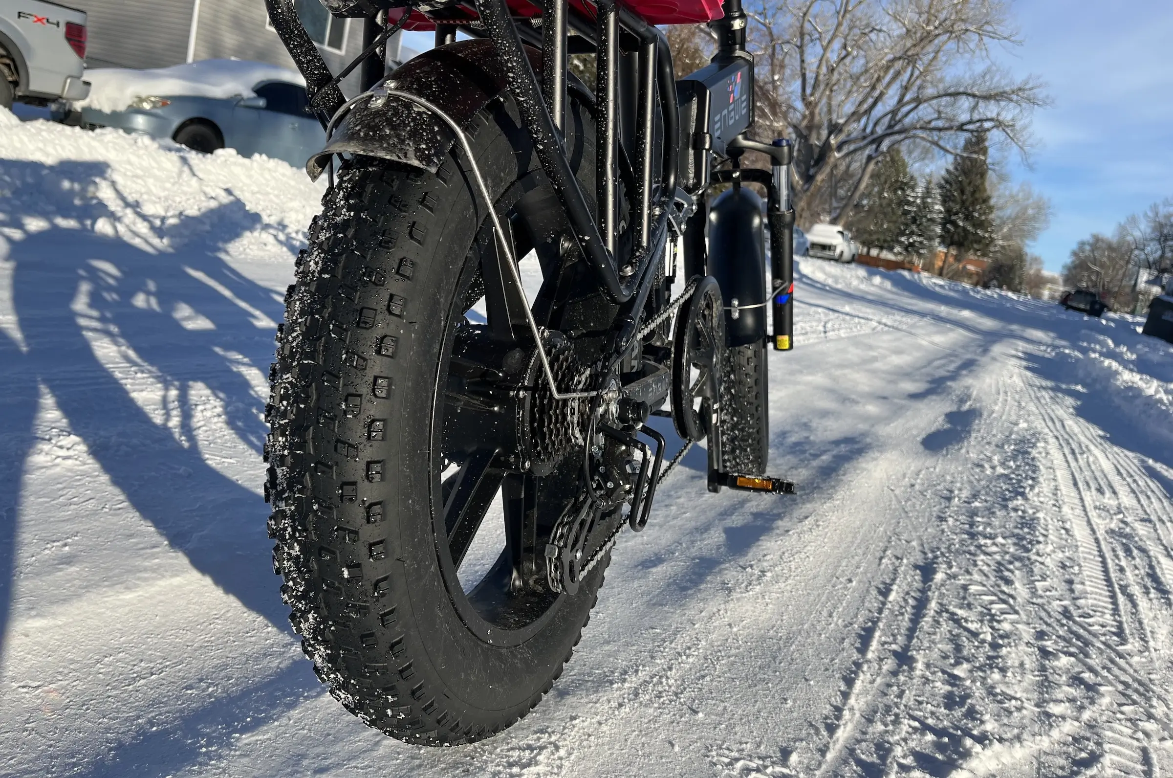 engwe Engine Pro close-up of rear gears and tires, on snowy road.