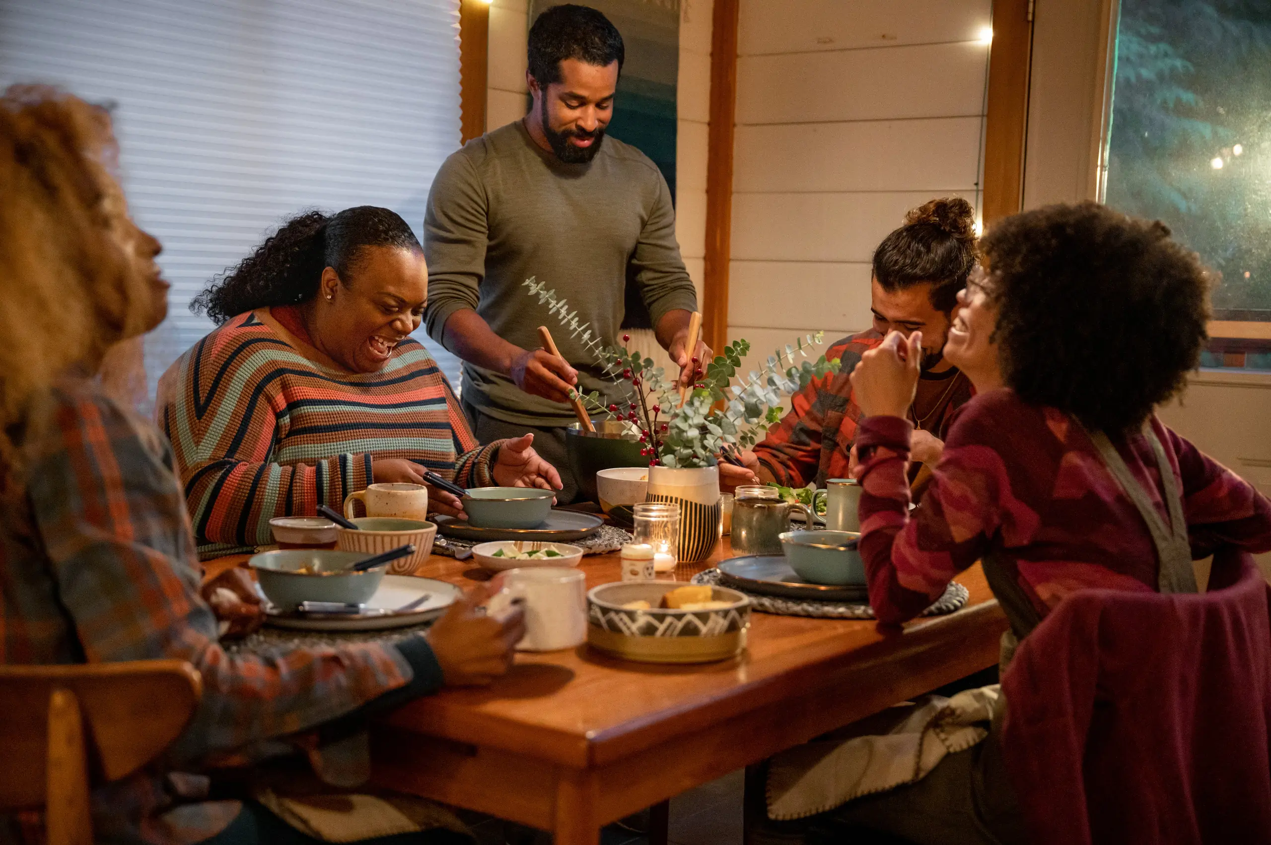 folks sitting around a table having a meal together folks sitting around a table having a meal together