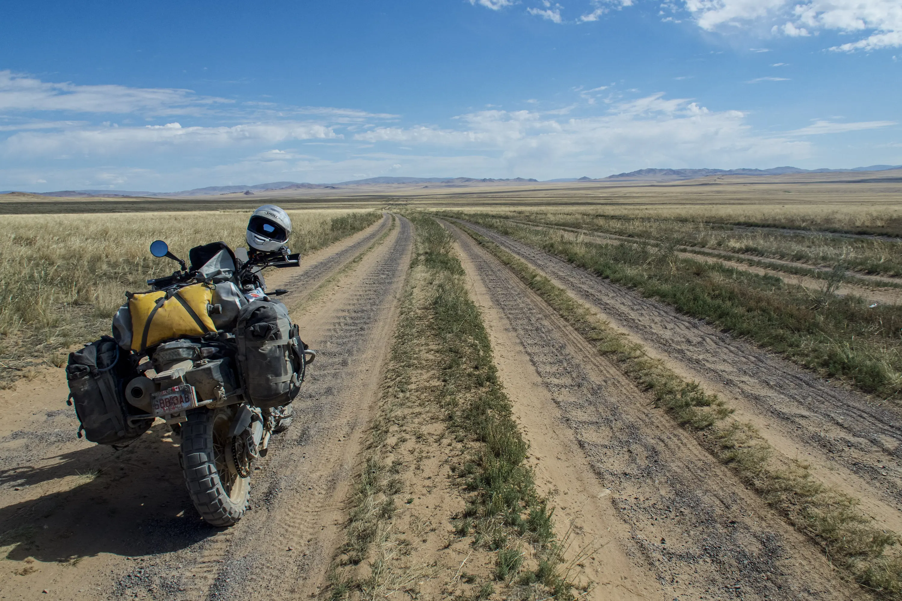 motorcycle on rough road in Mongolia motorcycle on rough dirt road showing washboard conditions in Mongolia