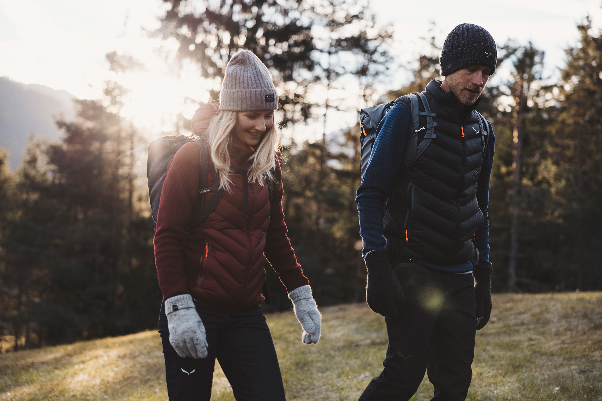 Two people walking through the mountains wearing Salewa
