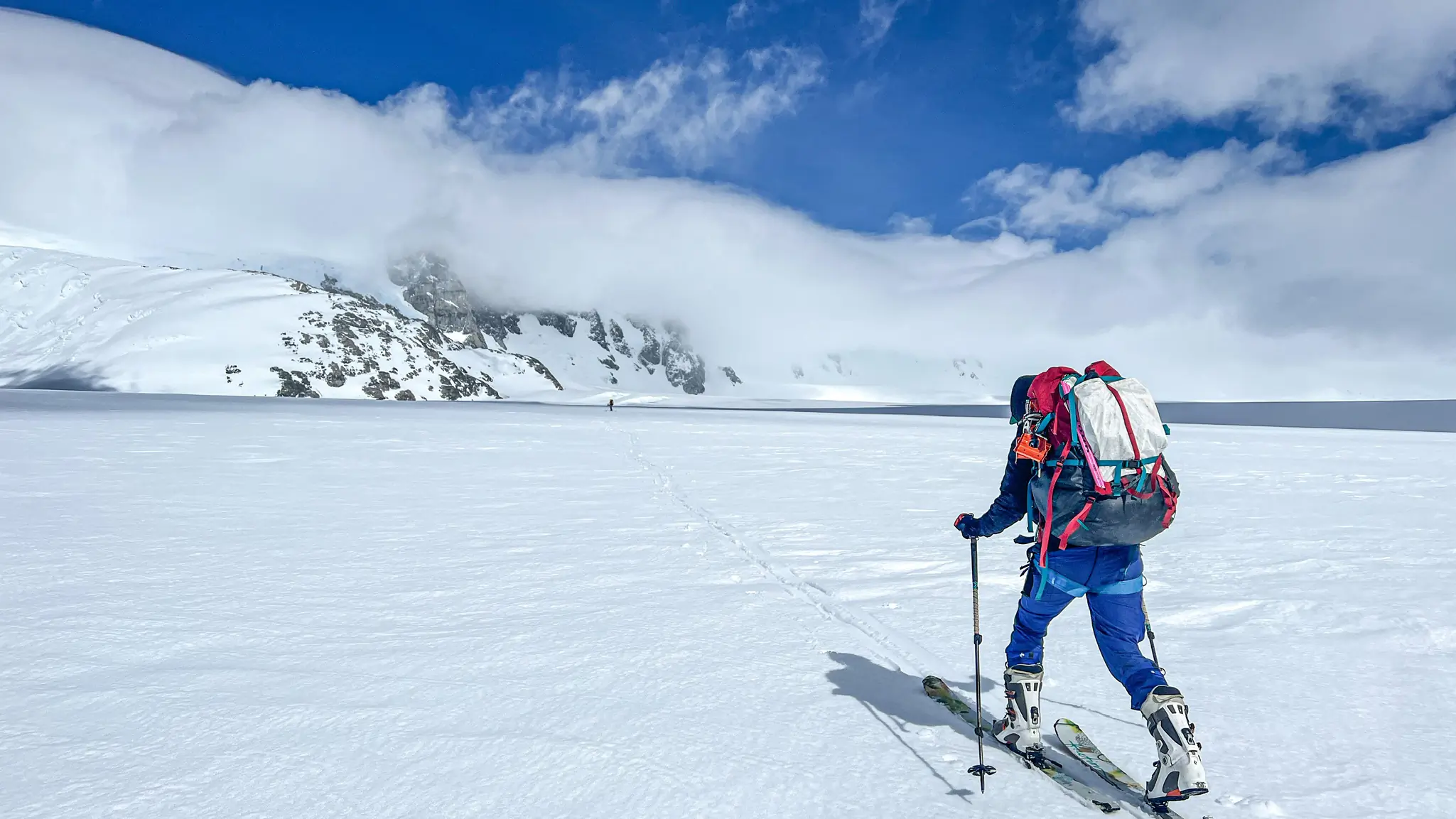 A womans skis toward a mountain