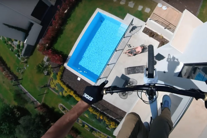 Kumping into a pool with a bicycle