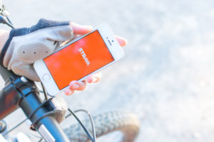 a hand holding a phone with the Strava app