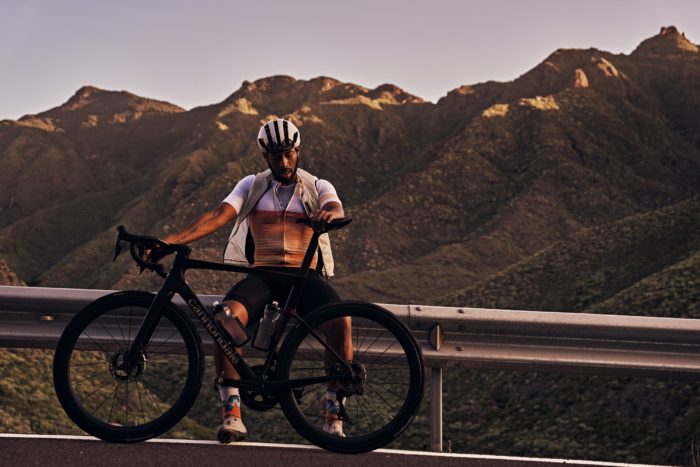 a cyclist resting on a guardrail