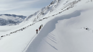 skiers ascending a mountain ridgeline