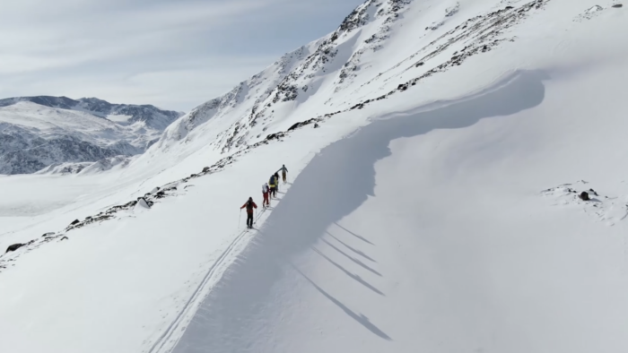 skiers ascending a mountain ridgeline