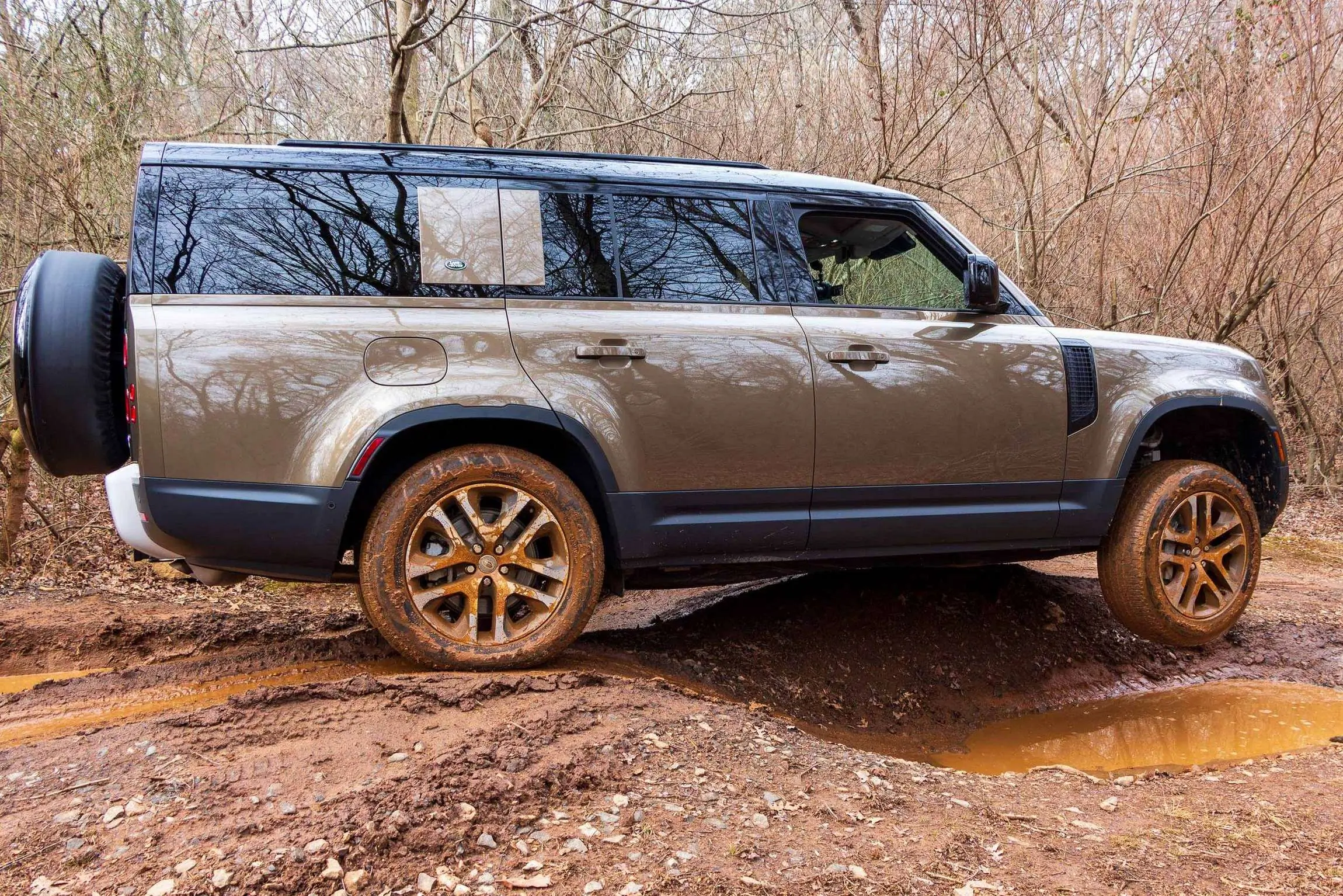 Land Rover Defender 130 Review side on muddy trail.