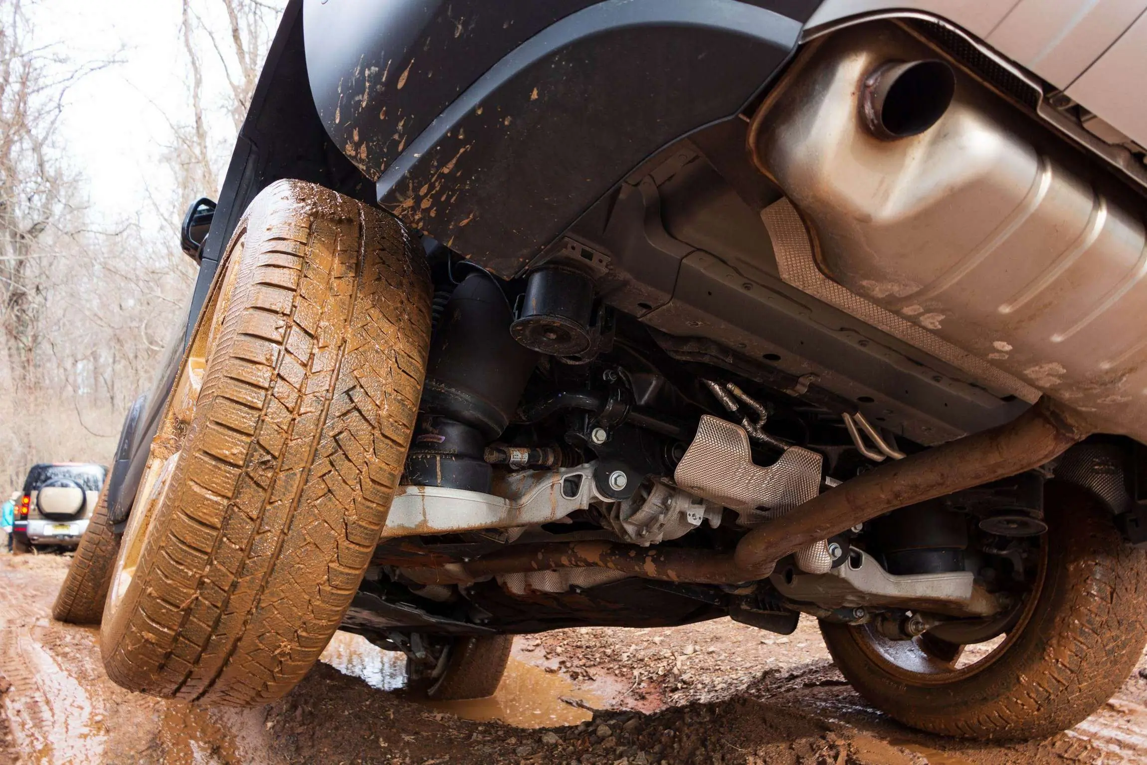 Land Rover Defender 130 Review underneath rear overhang on muddy trail.