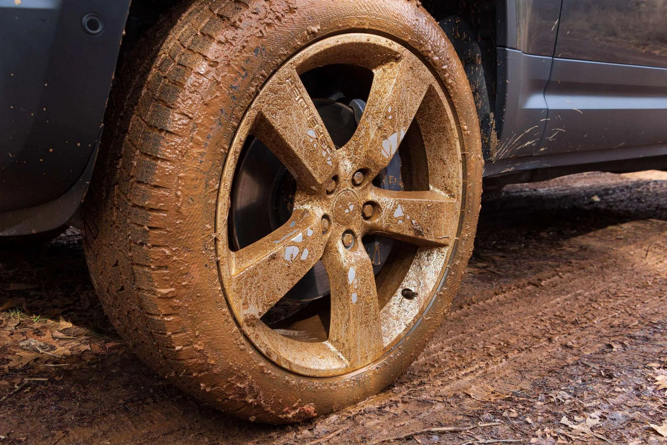Land Rover Defender 130 Review close-up of wheel in the mud.