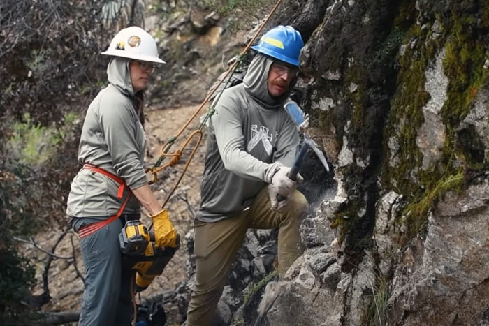 Two people working on a trail