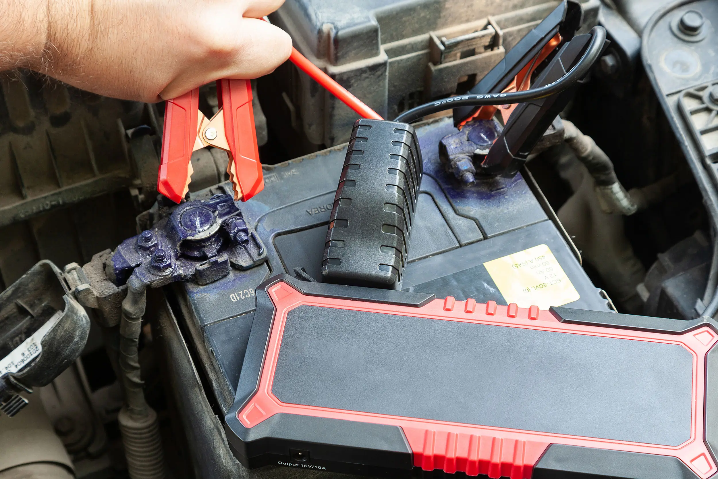 portable jumpstarter connected to 12V car battery