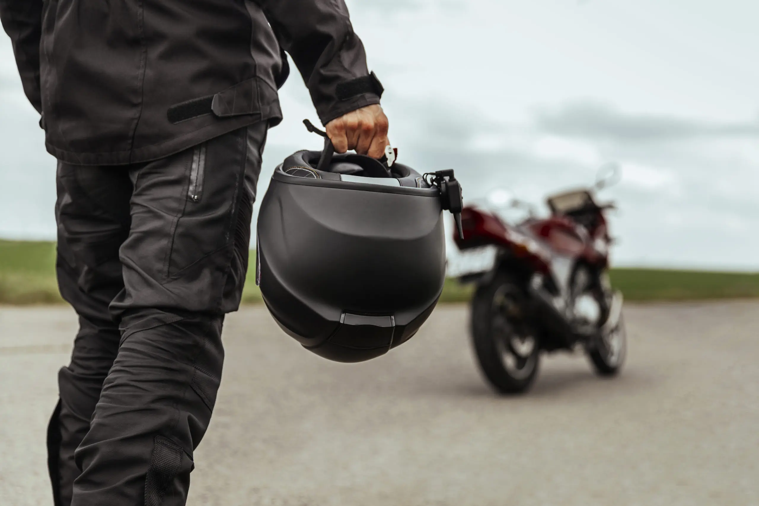 Choosing a motorcycle helmet rider holding a helmet with bike in the background