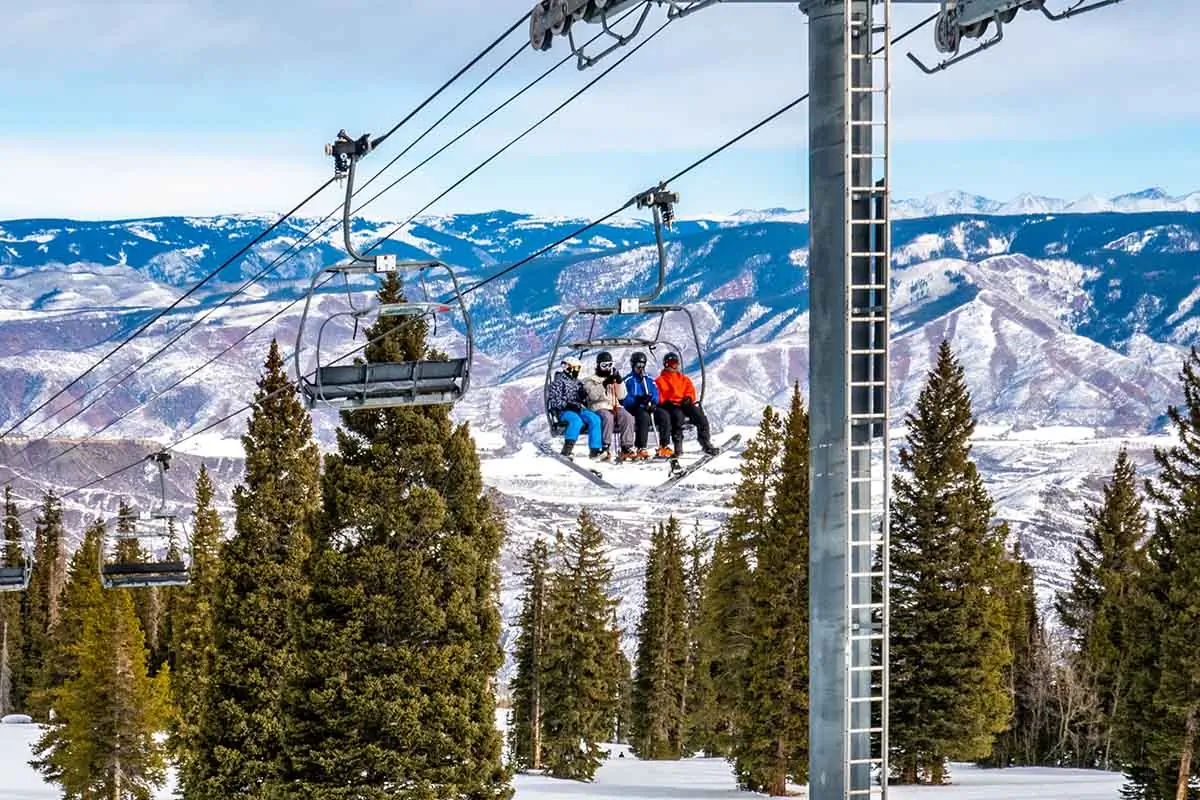 Skiers and snowboarders ascend the Alpine Springs chairlift at the Aspen Snowmass ski resort.