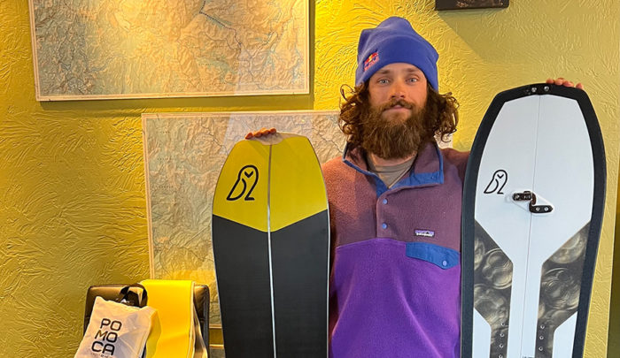 nick russell holding two splitboards up for auction